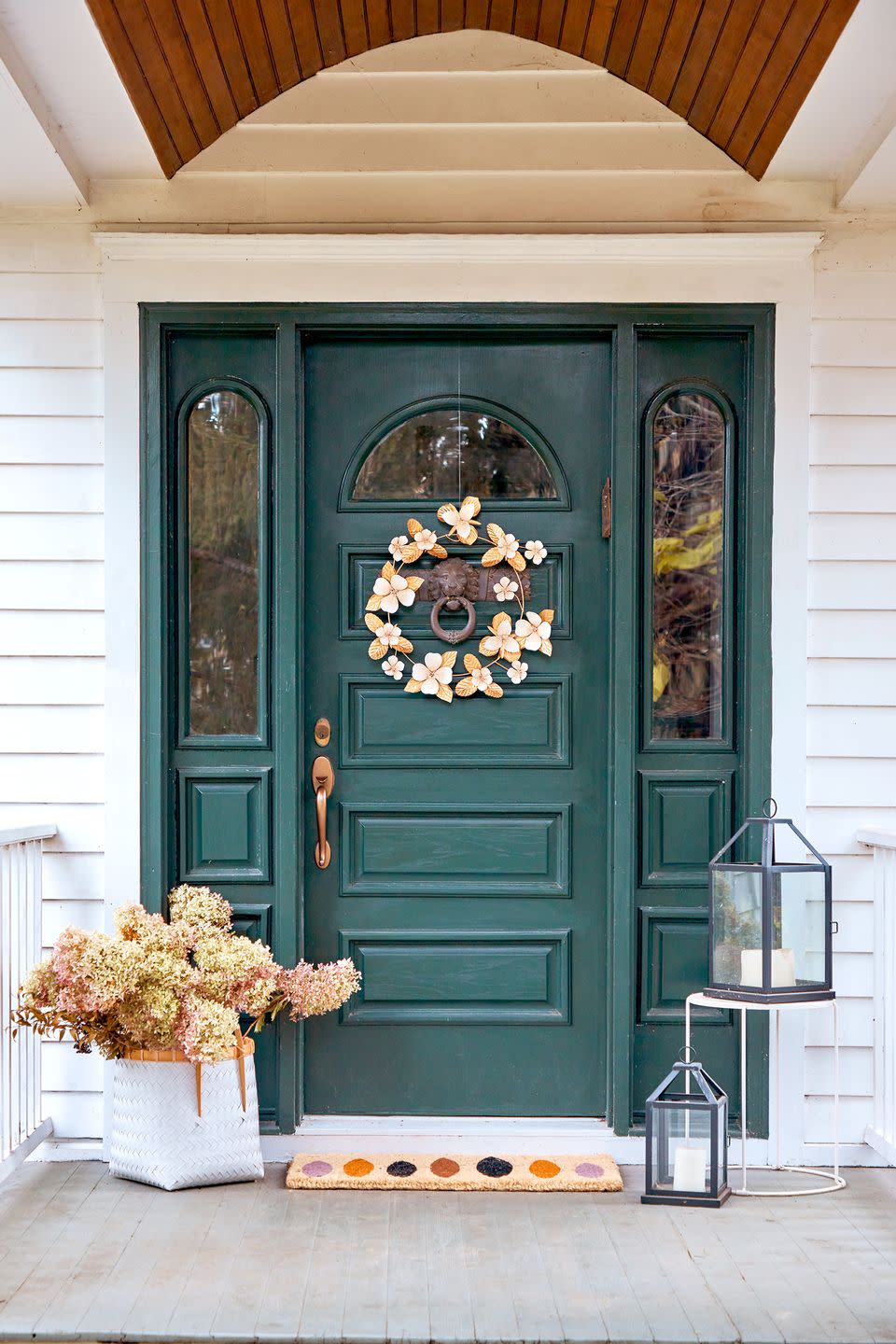 <p>A metallic floral wreath will complement dried hydrangeas beautifully (which offer a sustainable way to add florals and get a second life out of your summer favorites!). We love how the welcome mat ties the pale orange and lavender hues together.</p>