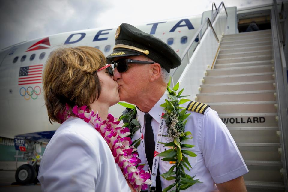 Delta Air Lines pilot Keith Rosenkranz kisses his wife Colette in front of an Airbus A330