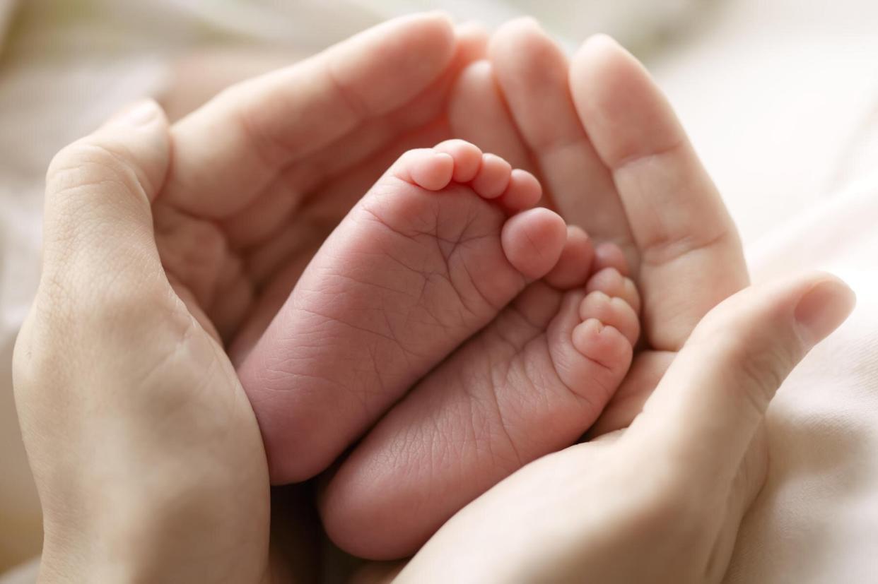 hands holding newborn baby feet