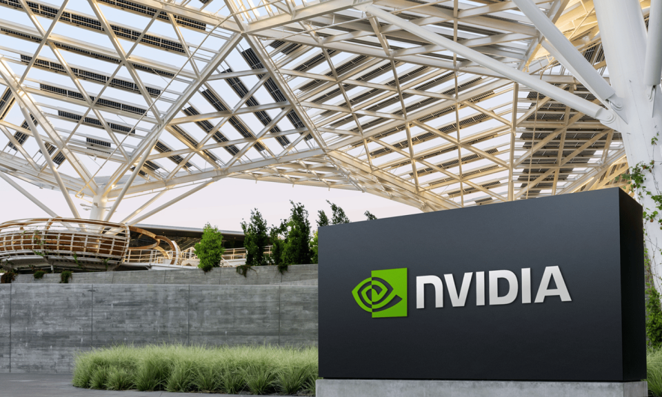 A sign with the Nvidia logo in front of a large glass building.