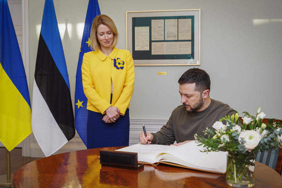 Estonia's Prime Minister Kaja Kallas, left, looks on as Ukrainian President Volodymyr Zelenskyy signs the guest book during their meeting, in Tallinn, Estonia, Thursday, Jan. 11, 2024. (AP Photo)