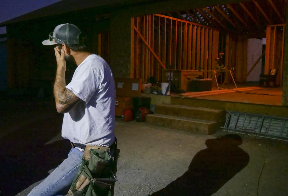 In this Monday, Nov. 4, 2019, photo, Bobbie Chandler stands in the home he and his wife Jenna, are building in Santa Rosa, Calif. Bobbie's parents' home of 20 years and thousands of other structures were destroyed by the Tubbs Fire and other wine country wildfires of 2017. The Chandler family rose from the ashes, rebuilding after losing their longtime family home to in the devastating firestorms that swept across California wine country in 2017. So as Bobbie Chandler nervously watched the orange glow of the Kincade Fire behind the ridge above the home he and his wife are building down the street from his parents, his gut twisted. (AP Photo/Lacy Atkins)