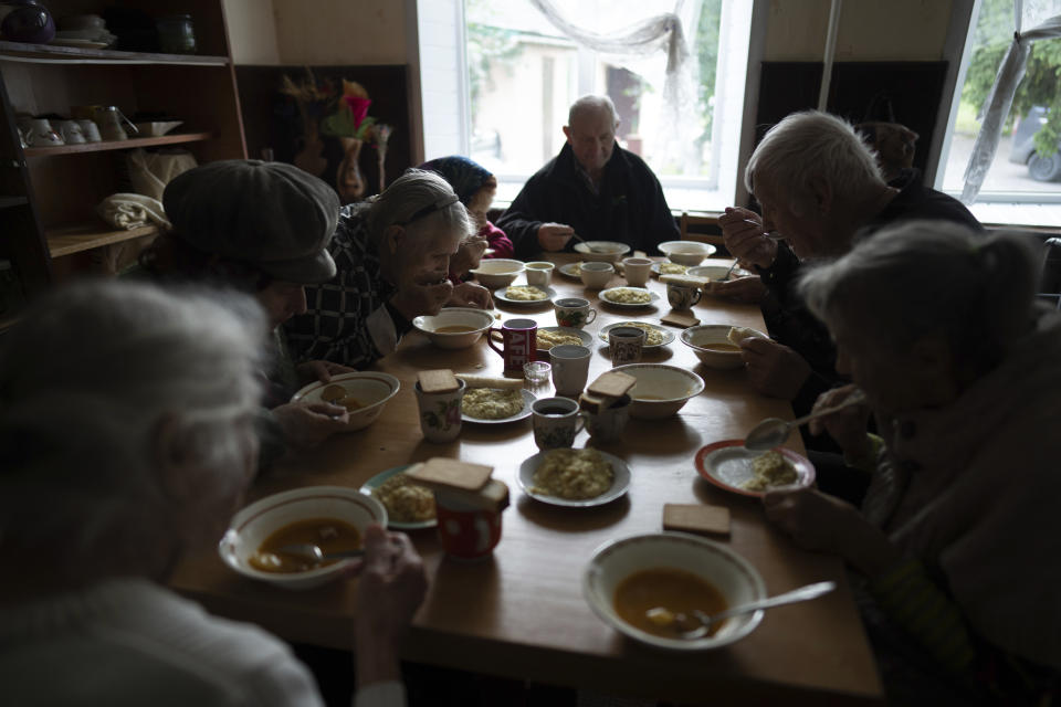 Patients eat a meal in a shelter for injured and homeless people in Izium, Ukraine, Monday, Sept. 26, 2022. A young Ukrainian boy with disabilities, 13-year-old Bohdan, is now an orphan after his father, Mykola Svyryd, was taken by cancer in the devastated eastern city of Izium. (AP Photo/Evgeniy Maloletka)