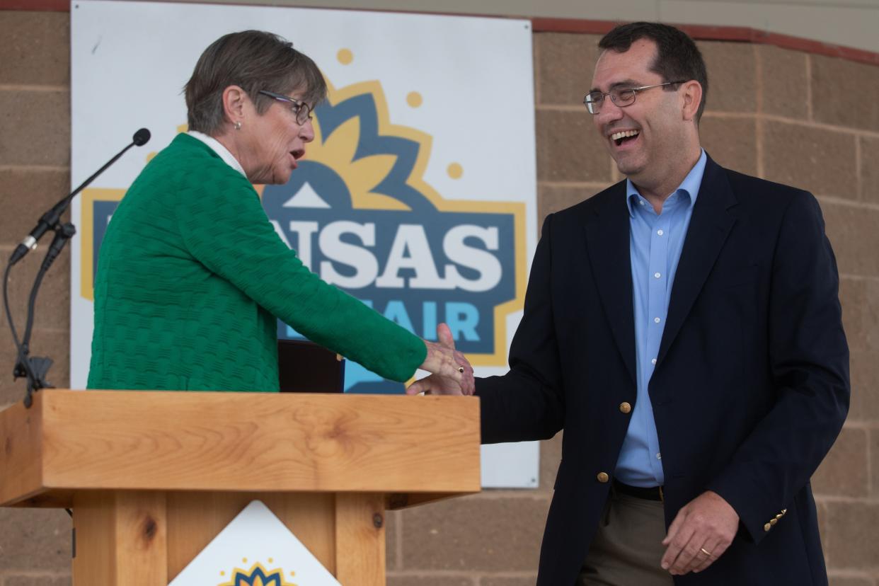 Gov. Laura Kelly and Attorney General Derek Schmidt exchange a handshake a words following the Kansas State Fair debate in Hutchinson.