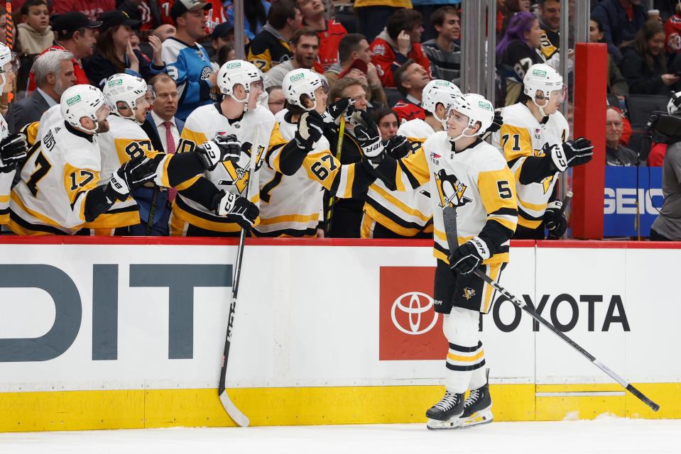 Pittsburgh Penguins defenseman Ryan Shea (5) celebrates with teammates after scoring a goal against the Washington Capitals in the first period at Capital One Arena on Thursday, April 4, 2024.