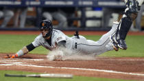 Detroit Tigers' Javier Baez scores on a throwing error by Tampa Bay Rays shortstop Jose Caballero as catcher Rene Pinto reaches for a high throw during the fifth inning of a baseball game Monday, April 22, 2024, in St. Petersburg, Fla. (AP Photo/Chris O'Meara)