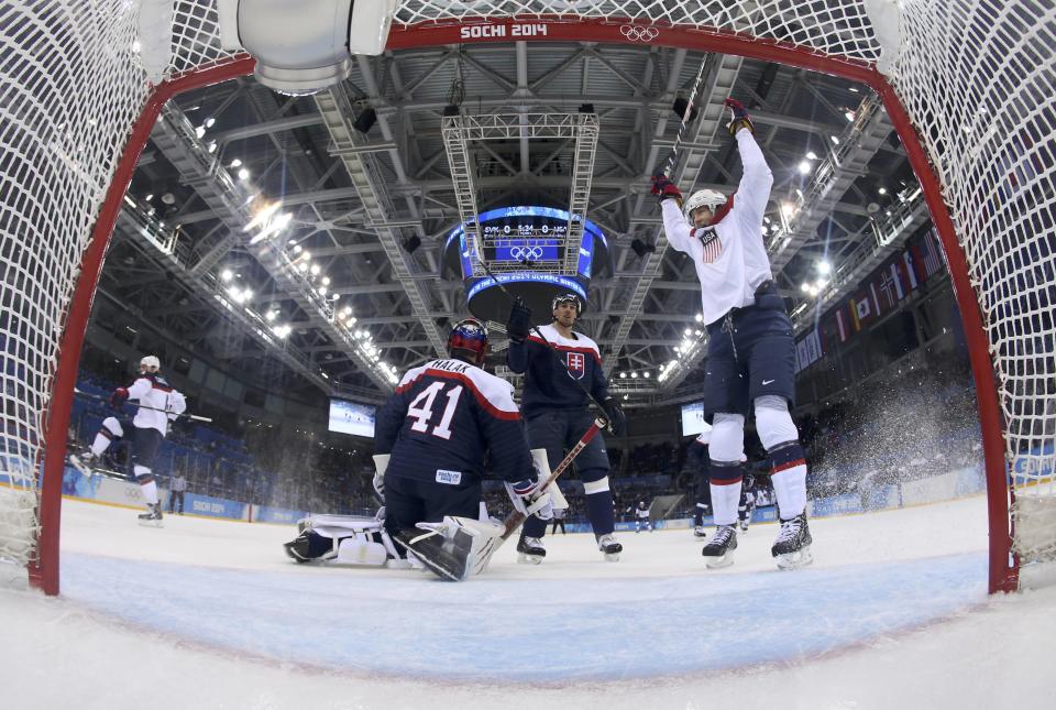 Team USA's John Carlson (L) celebrates his goal on Slovakia's goalie Jaroslav Halak (41) as Team USA's James van Riemsdyk (R) reacts during the first period of their men's preliminary round ice hockey game at the 2014 Winter Olympic Games, February 13, 2014. REUTERS/Martin Rose/Pool (RUSSIA - Tags: OLYMPICS SPORT ICE HOCKEY)