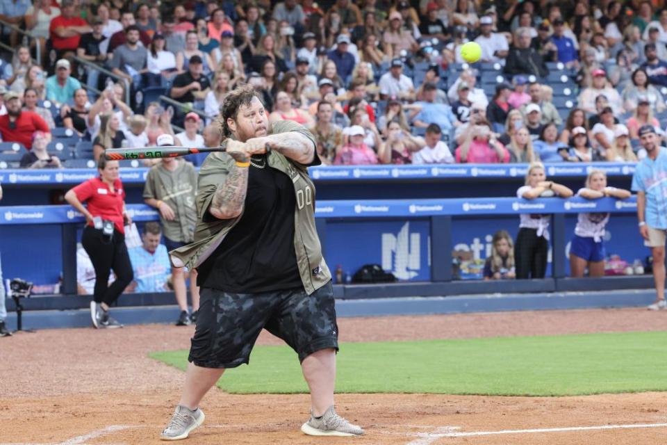 jelly roll swinging a bat while playing softball