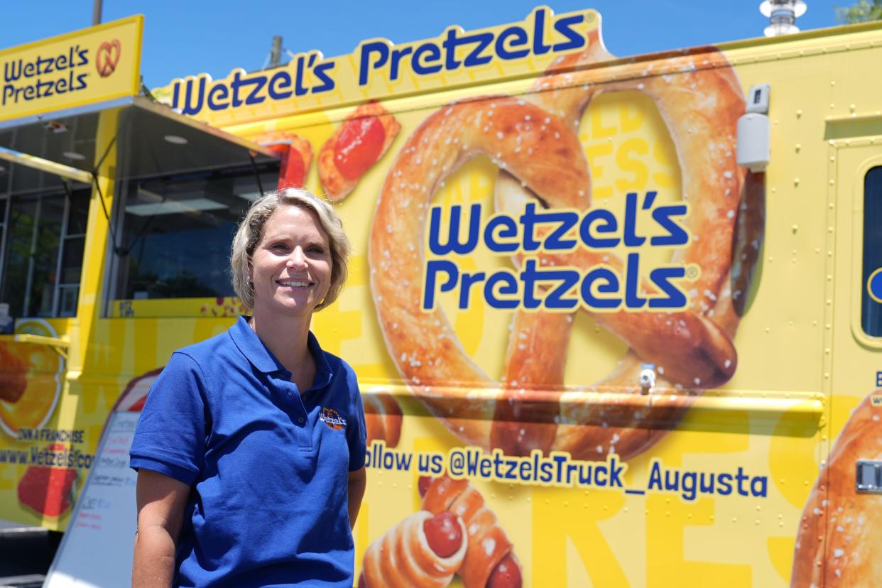 Owner Nancy Akers poses for a portrait in front of the new Wentzel's Pretzels food truck parked at Petersburg Shoppes on Fury's Ferry Road on Wednesday, July 10, 2024.