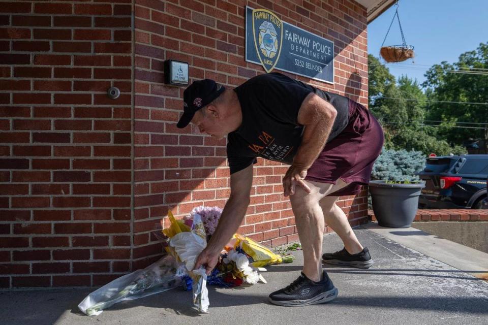 William Thornton, from Roeland Park, leaves flowers at the Fairway Police Department on Tuesday, Aug. 8, 2023, in Fairway, Kan. Thornton is a neighbor of the community and wanted to pay his respects to the officer, identified as 29-year-old Jonah Oswald, who was killed in the line of duty.