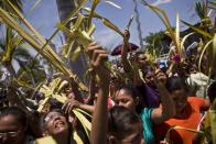 People hold up palm fronds during a Palm Sunday procession outside the Metropolitan Cathedral in Managua, Nicaragua, Sunday, April 13, 2014. For Christians, Palm Sunday marks Jesus Christ's entrance into Jerusalem, when his followers laid palm branches in his path, prior to his crucifixion. (AP Photo/Esteban Felix)