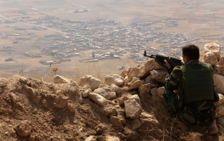 An Iraqi Kurdish Peshmerga fighter keeps watch from the top of Mount Zardak, about 25 kilometres east of Mosul