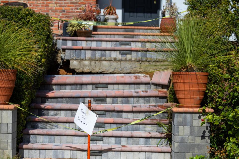 Front steps have cracked and dropped nearly a foot at a home with yellow caution tape in front of it.