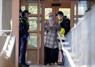 Police talk to a woman at housing commission apartments under lockdown in Melbourne, Australia, on Monday, July 6, 2020. The leader of Australia’s most populous state says her government’s decision to close its border with hard-hit Victoria state marks a new phase in the country’s coronavirus pandemic.(AP Photo/Andy Brownbill)