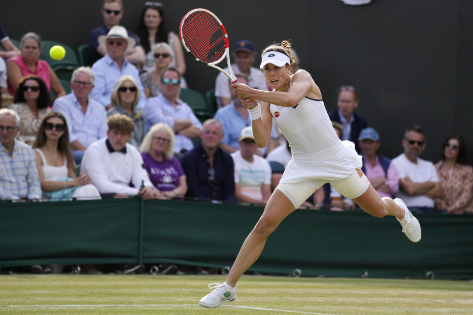 France's Alize Cornet attempts to return the ball to Australia's Ajla Tomljanovic during a women's singles fourth round match on day eight of the Wimbledon tennis championships in London, Monday, July 4, 2022. (AP Photo/Kirsty Wigglesworth)