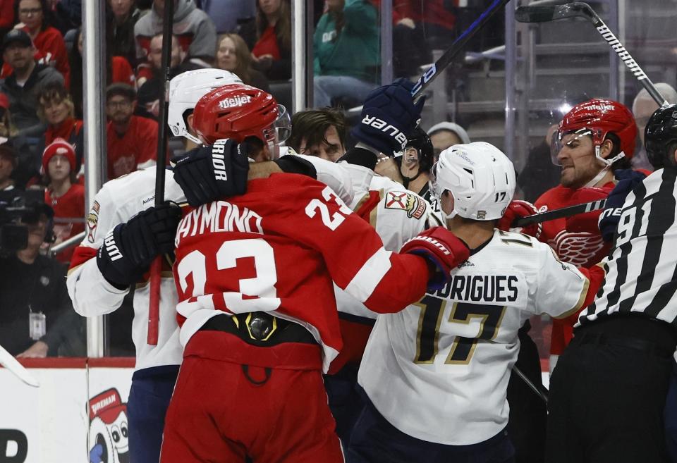 Detroit Red Wings left wing Lucas Raymond (23) and Florida Panthers center Evan Rodrigues (17) are involved in a scrum during the first period of an NHL hockey game Saturday, March 2, 2024, in Detroit. (AP Photo/Duane Burleson)