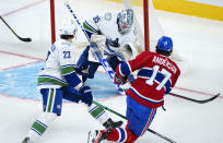 Vancouver Canucks goaltender Thatcher Demko blocks a shot off Montreal Canadiens' Josh Anderson as defenseman Oliver Ekman-Larsson (23) looks on during the second period of an NHL hockey game, Monday, Nov. 29, 2021 in Montreal. (Paul Chiasson/The Canadian Press via AP)