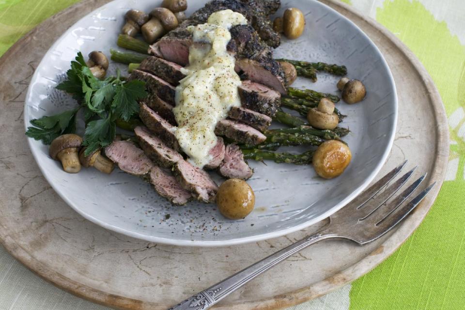 In this image taken on March 11, 2013, grilled lamb steaks with artichoke lemon sauce are shown served on a plate in Concord, N.H. (AP Photo/Matthew Mead)