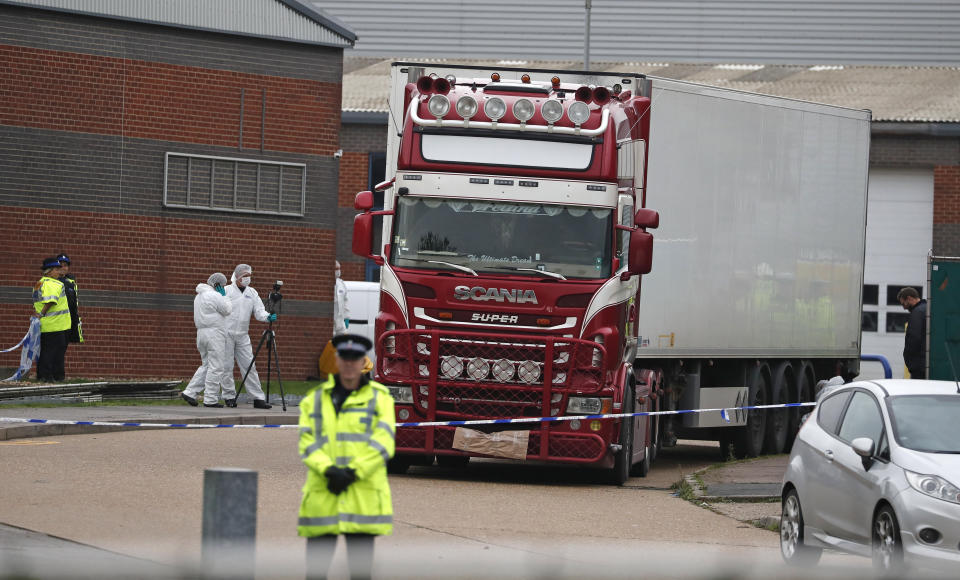 FILE - In this Oct. 23, 2019, file photo, police forensic officers attend the scene after a truck was found to contain a large number of dead bodies, in Thurrock, South England. The discovery in England of the bodies of 39 people believed to be from China lays bare some crucial but sometimes overlooked facts about China's development as a rising global power that has elevated hundreds of millions of its citizens to the middle classes. (AP Photo/Alastair Grant, File)