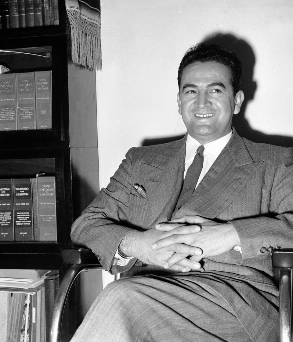 FILE - This May 2, 1949, photo shows Dr. Hector Perez Garcia, 35, a civil rights leader who placed an emphasis on Latinos assimilating into the United States, in his Corpus Christi, Texas office. Beliefs that Hispanics and Asians living in the U.S. won't assimilate or refuse to speak English are based on stereotypes that scholars say are linked to notions of white supremacy. Throughout American history, Hispanics and Asians have been pressured to adopt the customs of the mainstream white population. The pressure came even as some laws forbade them from voting, intermarrying and having access to education and public facilities. (AP Photo, File)