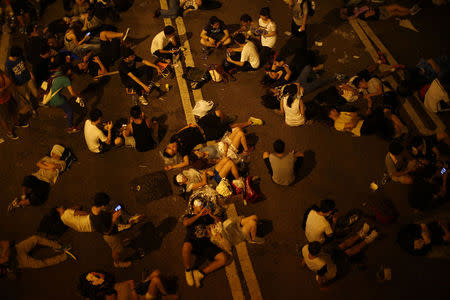 Some of the protesters sleep as they block the main street to the financial Central district outside the government headquarters, with other demonstrators in Hong Kong, September 29, 2014. REUTERS/Carlos Barria