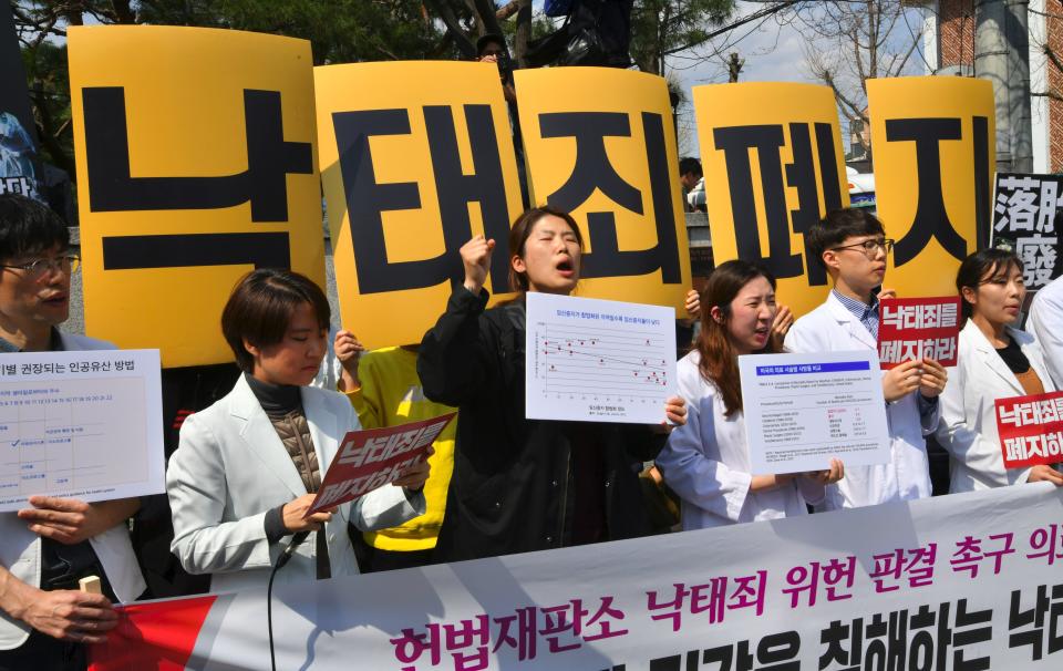 South Korean women's rights activists hold a rally against the abortion ban outside the Constitutional Court in Seoul on April 11. The yellow placards read "Abolish punishment for abortion." (Photo: JUNG YEON-JE via Getty Images)