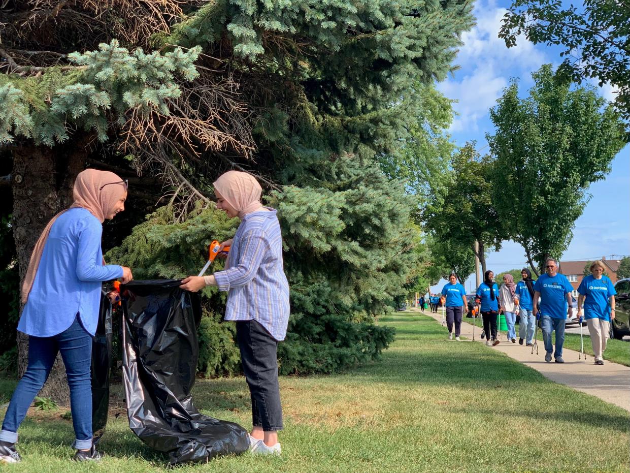Lena Abukhamireh, left, and Leya Rizeq pick up trash during the second annual Interfaith Neighborhood Clean-up, organized by the Church of Jesus Christ of Latter-day Saints and the Islamic Society of Milwaukee, on Saturday near South 13th Street and Layton Avenue. Abukhamireh and Rizeq are recent graduates of Marquette University, where they were leaders of the organization Students for Justice in Palestine.