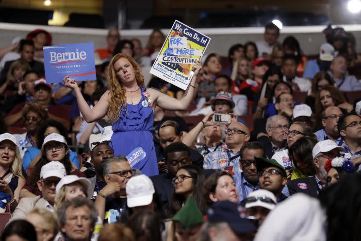 A Bernie Sanders supporter holds up signs during the first day of the Democratic National Convention in Philadelphia. (AP Photo/Matt Rourke)