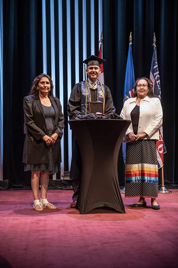 Chase Soosay receives the President's Medal during his MacEwan University convocation in July. Standing beside him are his aunt Gilda Soosay, left, and mother Violet Soosay, right. (Submitted by Allan Linklater - image credit)