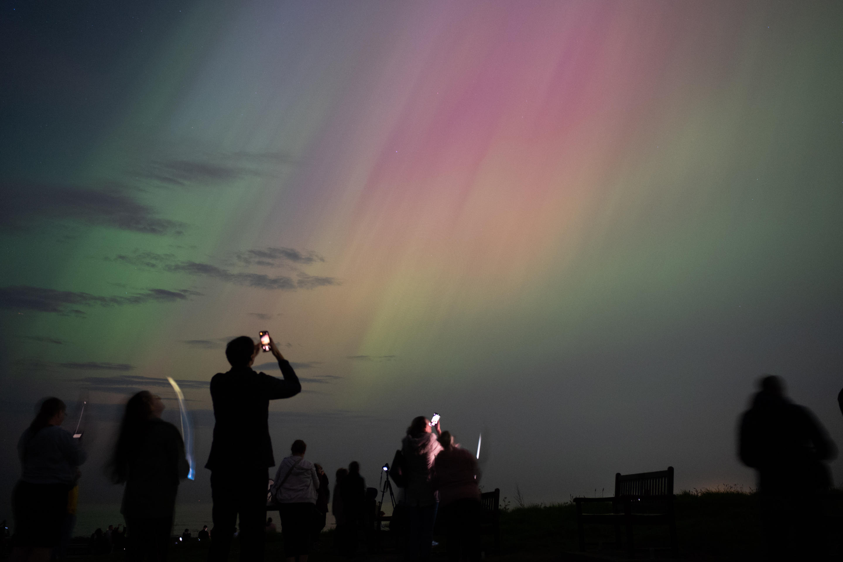 WHITLEY BAY, ENGLAND - MAY 10: People visit St Mary's lighthouse in Whitley Bay to see the aurora borealis, commonly known as the northern lights, on May 10, 2024 in Whitley Bay, England. The UK met office said a strong solar storm may allow northern parts of the UK the chance to see displays of aurora.  (Photo by Ian Forsyth/Getty Images)