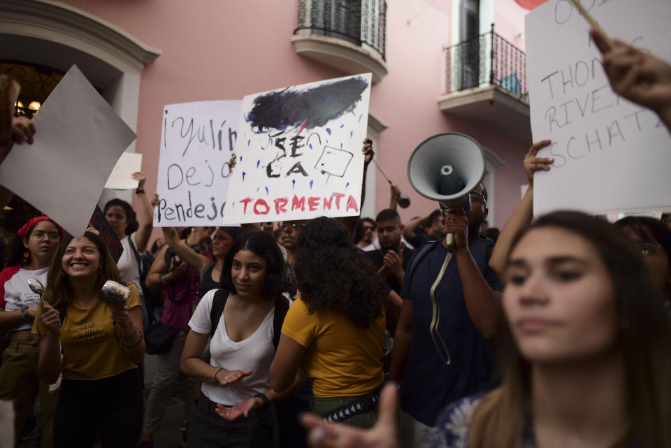A young man holds a sign that reads in Spanish "Be the storm" while protesting outside the executive mansion known has La Fortaleza, in Old San Juan, demanding the resignation of Governor Wanda Vazquez after the discovery of an old warehouse filled with unused emergency supplies in San Juan, Puerto Rico, Monday, Jan. 20, 2020. Anger erupted on Saturday after an online blogger posted a live video of the warehouse in the southern coastal city of Ponce filled with water bottles, cots, baby food and other basic supplies that had apparently been sitting there since Hurricane Maria battered the U.S. territory in September 2017. (AP Photo/Carlos Giusti)