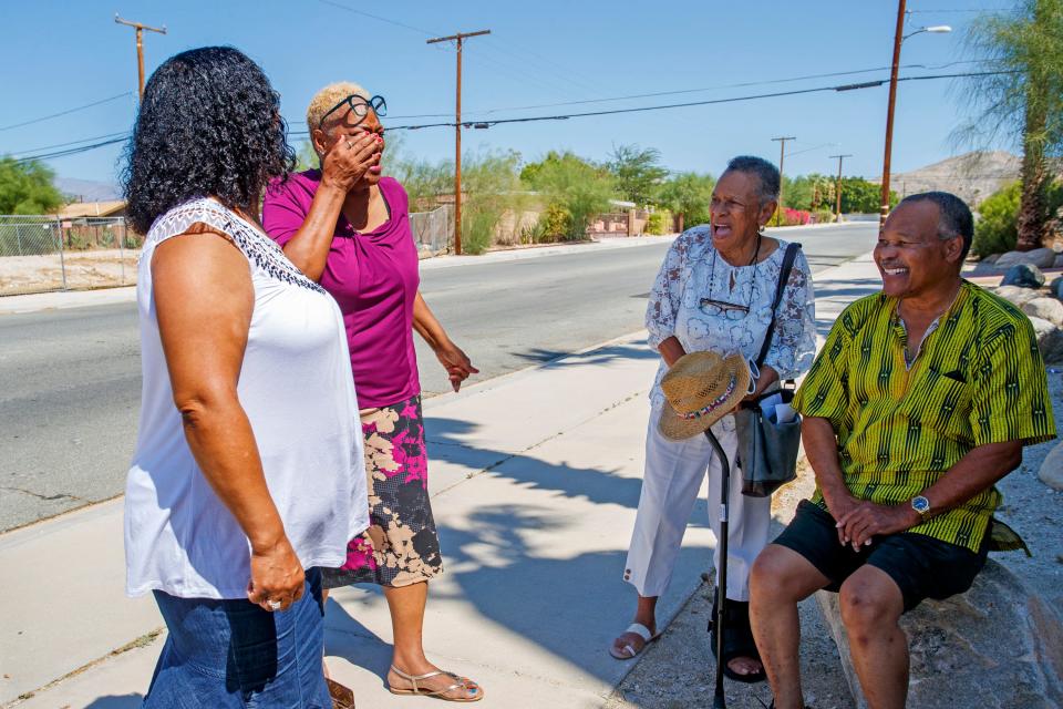 First Community Baptist Church members Crystal Baylark, left, Maunaloa Hill, Bette Stampley, and Tommy Enge talk about the closeness of their church body outside the church in Desert Hot Springs, Calif., August 10, 2022. An April fire destroyed parts of the church building. Members continue to meet mostly virtually until renovations are complete.