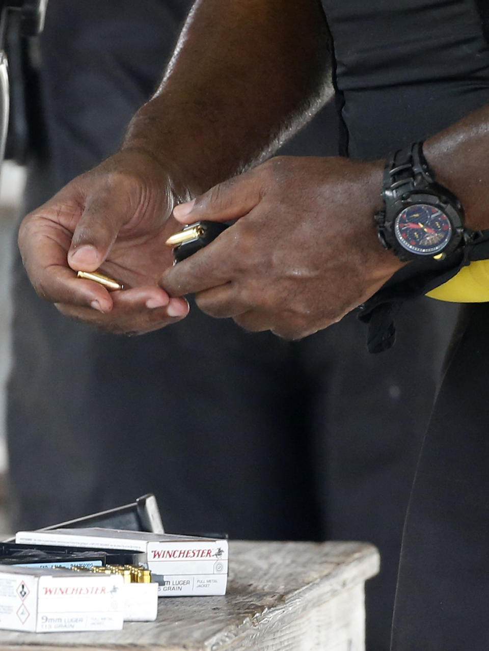 In this Monday, July 30, 2018 photo, one of the Broward County Public Schools' newly-hired armed guardians loads a magazine with bullets during firearms training at Broward Sheriff's Office gun range at Markham Park in Sunrise, Fla. Twenty-two of the Florida school districts are supplementing officers with "guardians" -- armed civilians or staff. They are vetted, receive 132 hours of training and must attain a higher score on the state firearms test than rookie police officers. (AP Photo/Wilfredo Lee)