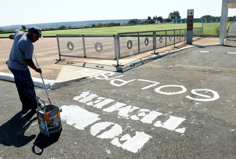 A worker removes the inscription "Temer Out", written on the street in front of the Alvorada Palace presidential residence on September 1, 2016 in Brasilia