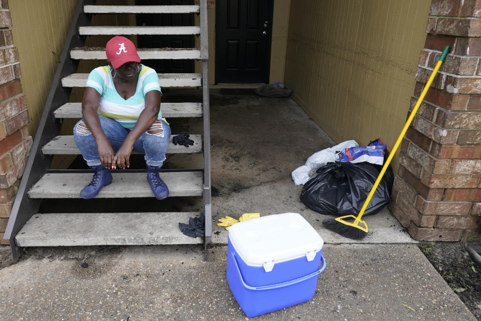 Karen Robinson takes a break after cleaning out her apartment in the aftermath of flooding after Hurricane Sally moved through, Friday, Sept. 18, 2020, in , Fla. (AP Photo/Gerald Herbert)