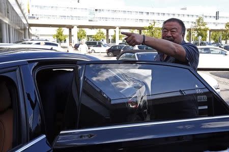 Dissident Chinese artist Ai Weiwei gestures as he leaves the airport in Munich, Germany July 30, 2015. REUTERS/Michaela Rehle