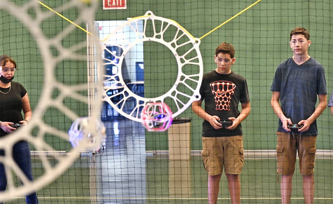 Xitlali DeLaCruz, 11, left, Moises Hernandez-Juarez, 13, and his brother Diego, 15, right, pilot drones during Drone Soccer camp at Modesto Junior College in Modesto, Calif., on Friday, June, 24, 2022.