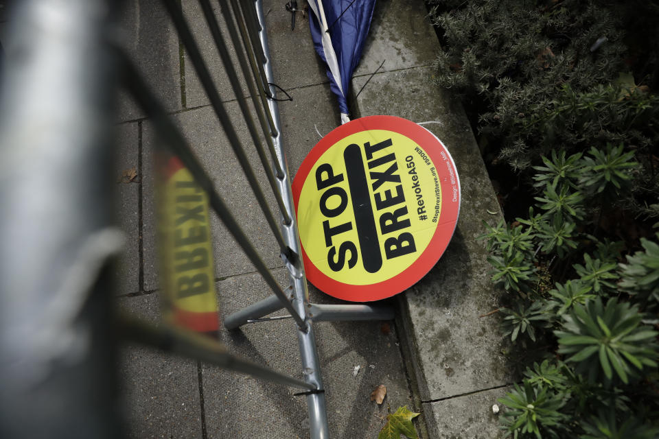 A stop Brexit placard lies across the street from the Houses of Parliament in London, Tuesday, Oct. 15, 2019. A Brexit divorce deal is still possible ahead of Thursday's European Union summit but the British government needs to move ahead with more compromises to seal an agreement in the next few hours, the bloc said Tuesday. (AP Photo/Matt Dunham)