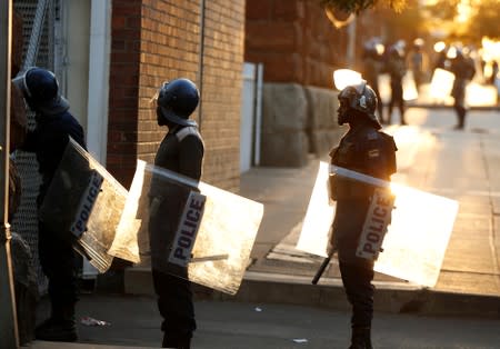 Riot police officers keep watch outside the Tredgold Building Magistrate court in Bulawayo