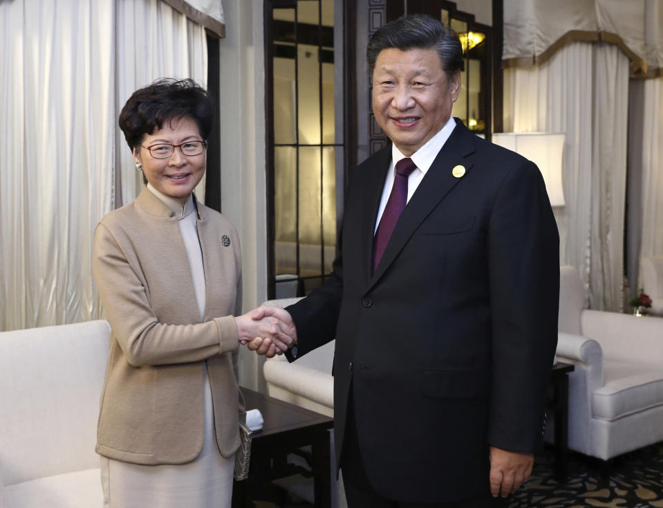 FILE - In this Nov. 4, 2019, file photo released by China's Xinhua News Agency, Chinese President Xi Jinping, right, poses with Hong Kong Chief Executive Carrie Lam for a photo during a meeting in Shanghai, China. A sharp escalation of violence in Hong Kong has once again raised the question of how China's central government will respond. Experts said national security measures and deployment of the armed forces remain possibilities, though Beijing may just as likely allow destruction to continue unfolding. (Ju Peng/Xinhua via AP, File)