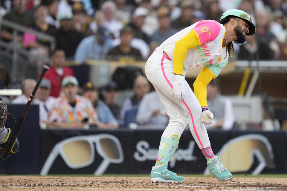 San Diego Padres' Fernando Tatis Jr. grimaces after being hit by a pitch during the third inning of a baseball game against the Milwaukee Brewers, Friday, June 21, 2024, in San Diego. (AP Photo/Gregory Bull)