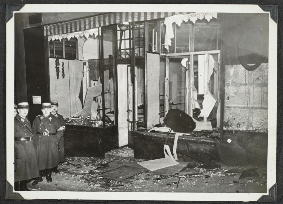 This photo released by Yad Vashem, World Holocaust Remembrance Center, shows German Nazis stand by ransacked Jewish property during Kristallnacht intake most likely in the town of Fuerth, Germany on Nov. 10, 1938. The photos were taken by Nazi photographers during the pogrom in the city of Nuremberg and the nearby town of Fuerth. They wound up in the possession of a Jewish American serviceman who served in Germany during World War II. His descendants,donated the album to Yad Vashem. (Yad Vashem via AP)