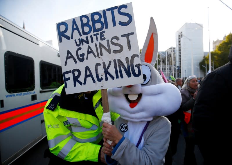 FILE PHOTO: A police officer moves a protester outside the Houses of Parliament during a demonstration against fracking, in London
