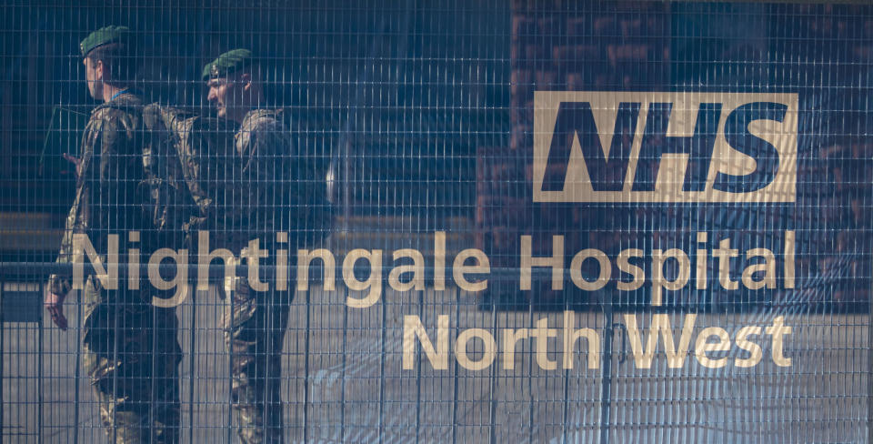 Members of the Military behind hoardings during final preparations at the National Health Service (NHS) Nightingale North West hospital which is now open in Manchester, England, Tuesday April 14, 2020. The Nightingale North West hospital was built in 14-days at the main central hall of the former Manchester Central railway station, and is capable of treating some 750 virus patients.  The highly contagious COVID-19 coronavirus has impacted on nations around the globe, many imposing self isolation and exercising social distancing when people move from their homes. (Peter Byrne / PA via AP)