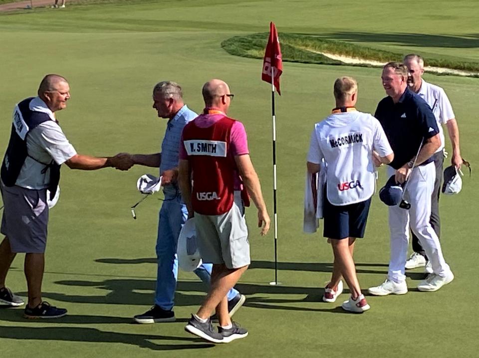 Mick Smith de Summit, segundo desde la derecha, se da la mano después de completar su segunda ronda en el US Senior Open en SentryWorld en Stevens Point el viernes.