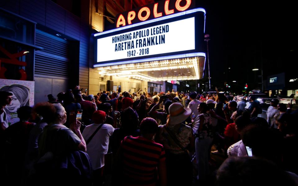 People gather at a makeshift memorial outside the Apollo Theater in Harlem where Franklin performed - AP