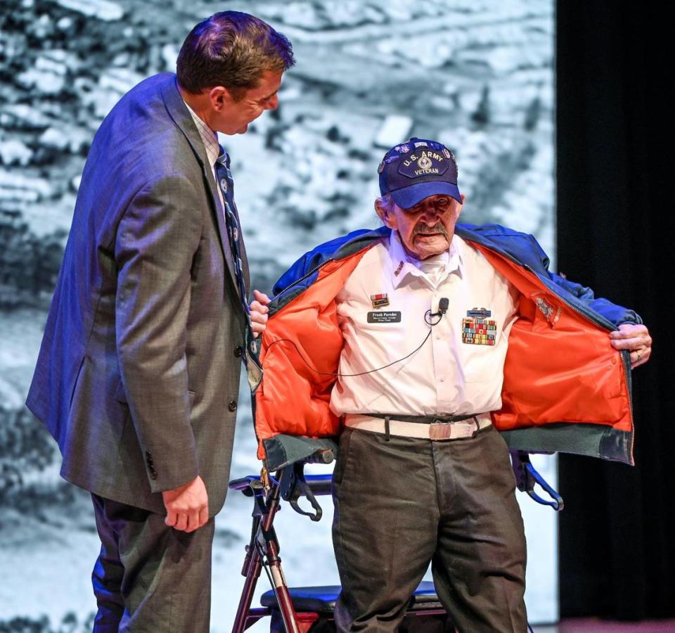 Francisco “Frank” Paredes, a survivor of the Dec. 7, 1941 attack on Pearl Harbor, stands from his rolling walker to show off his military service ribbons while being interviewed by Hometown Heroes Radio creator and host Paul Loeffler during a Pearl Harbor Remembrance Day ceremony a the Clovis Veterans Memorial District on Wednesday, Dec. 7, 2022.