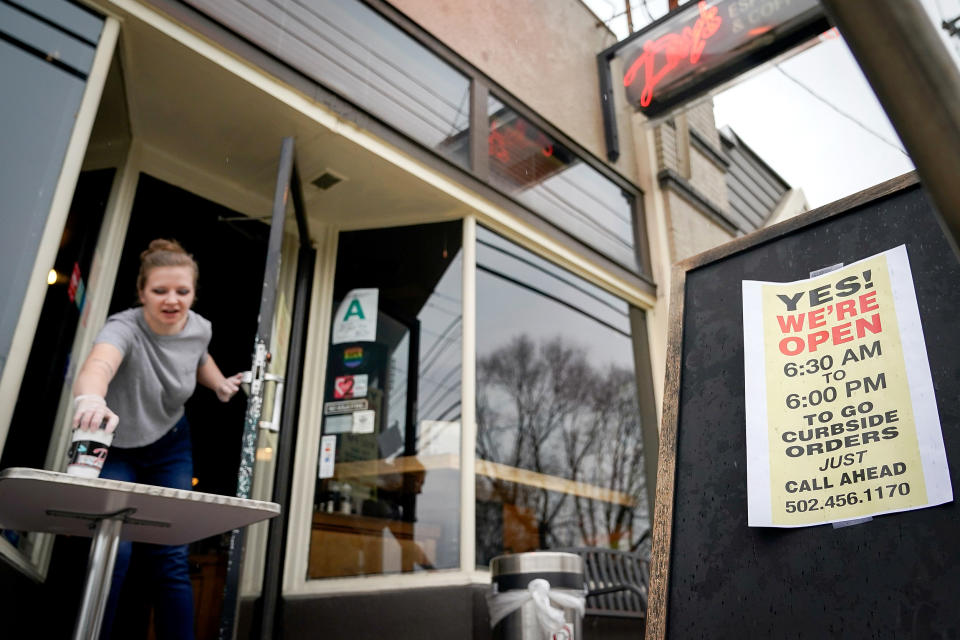 Image: Kayla Marx places an order outside the door of Day's Espresso and Coffee Shop after a state mandated carry-out only policy went into effect in order to slow the spread of the novel coronavirus (COVID-19) in Louisville (Bryan Woolston / Reuters)