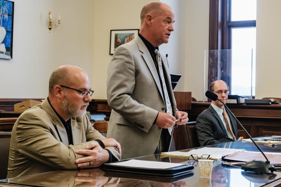 Attorney Matthew P. Mullen, center, addresses Judge Michael Ernest during the sentencing hearing of Jeffrey A. Stearns, left, Friday, at the Tuscarawas County Courthouse. Seated at right is Special Prosecutor Thomas Anger, representing the Ohio Auditor of State.