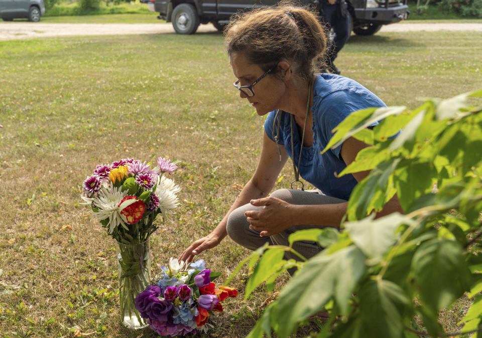 Ruby Works places flowers at the home of a victim who has been identified by residents as Wes Petterson in Weldon, Saskatchewan, on Monday, Sept. 5, 2022. Works said that the 77-years-old victim was like an uncle to her. Saskatchewan RCMP say arrest warrants have been issued for two suspects in a deadly stabbing rampage who remain at large. (Heywood Yu/The Canadian Press via AP)